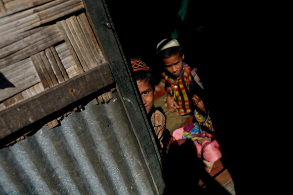  A Rohingya refugee boy stands at the entrance of his family's temporary shelter at the Leda refugee camp near Cox's Bazar, Bangladesh December 16, 2017. Photo by Alkis Konstantinidis 