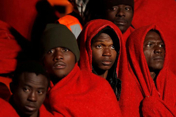  Migrants, part of a group intercepted aboard a dinghy off the coast in the Mediterranean Sea, look on as they stand on a rescue boat upon arrival on Christmas day at the port of Malaga, Spain December 25, 2017. Photo by Jon Nazca 