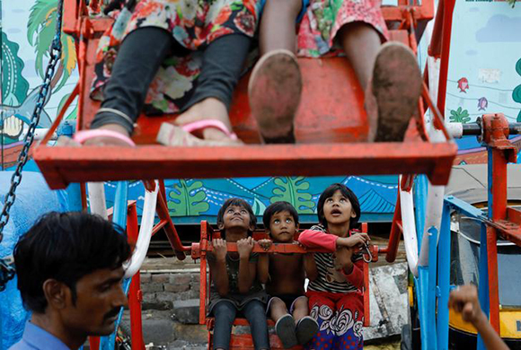  Children ride a manually-operated ferris wheel in a slum in Mumbai, India, December 27, 2017. Photo by Danish Siddiqui 