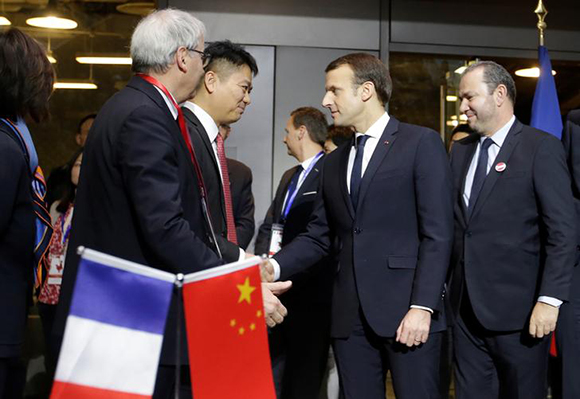  Richard Liu (2nd L), CEO and founder of China's e-commerce company JD.com, shakes hands with French President Emmanuel Macron after a signing ceremony at a France-Chinese forum on the applications of artificial intelligence at SOHO 3Q in Beijing, China January 9, 2018. Photo by Jason Lee 
