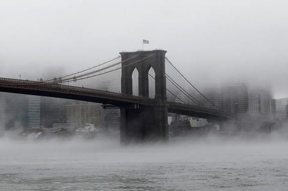  The Brooklyn Bridge is seen partially in fog from in front of the Manhattan skyline in Brooklyn, New York, U.S., January 12, 2018. Photo by Shannon Stapleton 