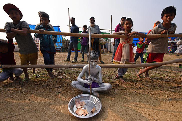  A boy begs for alms at the Jonbeel Mela festival, where people belonging to different tribes exchange their merchandise with locals through a barter system, in the Morigaon district, in the northeastern state of Assam, India January 19, 2018. Photo by Anuwar Hazarika 