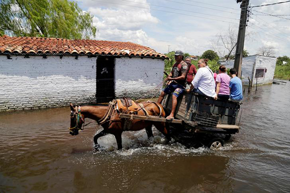  People ride on a horse carriage through a flooded street after heavy rains caused the river Paraguay to overflow, in Asuncion, Paraguay January 22, 2018. Photo by Jorge Adorno 