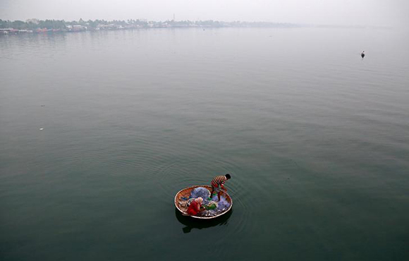  A fisherman and his wife catch fish in the waters of Vembanad Lake in Kochi, India, January 24, 2018. Photo by Sivaram 