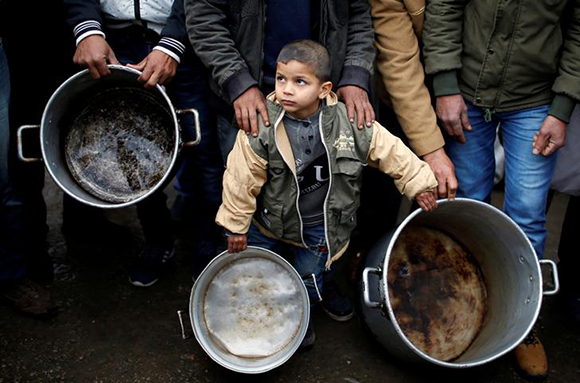  A Palestinian boy holds cooking pots during a protest against aid cuts, outside United Nations' offices in Gaza City January 24, 2018. Photo by Mohammed Salem 