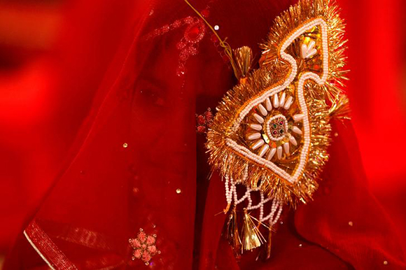  A bride adorned with a decorative sign on her dress waits for her wedding to start during a mass marriage ceremony organized by the Pakistan Hindu Council in Karachi, Pakistan, January 28, 2018. Photo by Akhtar Soomro 