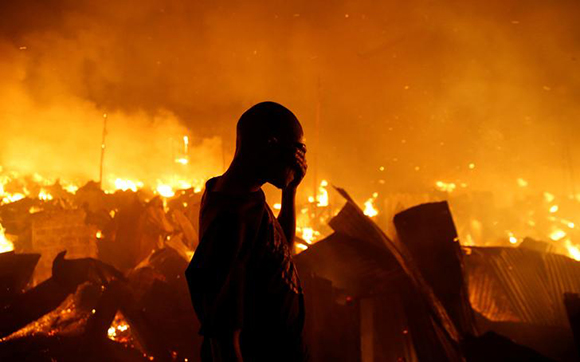  A resident reacts as he attempts to extinguish a fire that broke out at the Kijiji slums in the Southlands estate of Nairobi, Kenya, January 28, 2018. Photo by Thomas Mukoya 