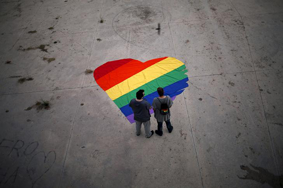  Fer Franco, 25, (L) and his partner Rafa Varon, 23, stand next to a heart-shaped cloth with rainbow colors as they pose for a photo, to mark Gay Pride day, in downtown Malaga, southern Spain Photo by Jon Nazca 