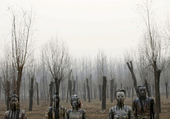  Models painted in camouflage colours to blend in with the background pose for Chinese artist Liu Bolin's artwork "Dongji", or Winter Solstice, on the second day after China's capital Beijing issued its second ever "red alert" for air pollution, in Beijing, China, December 20, 2015. Photo by Kim Kyung-Hoon 