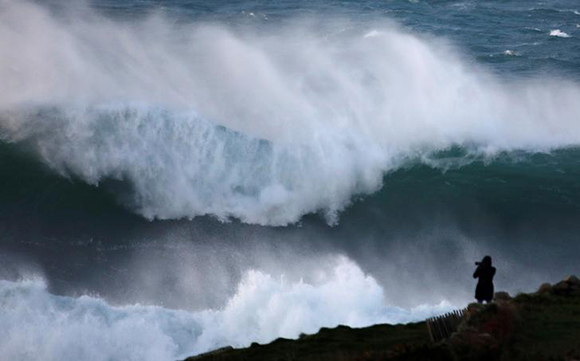  A photographer takes pictures of waves breaking on the Brittany coast at Audierne in western France Photo by Mal Langsdon 