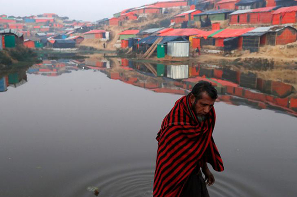  A Rohingya refugee walks next to a pond in the early morning at Balukhali refugee camp near Cox's Bazar, Bangladesh January 10, 2018. Photo by Tyrone Siu 