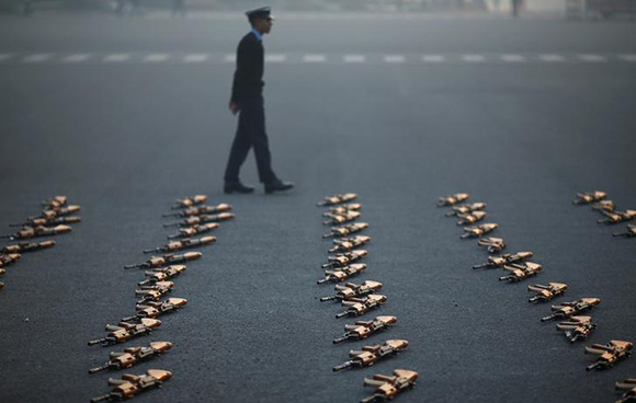  An Indian soldier stands guard next to rifles during a rehearsal for the Republic Day parade on a winter morning in New Delhi, India, January 22, 2018. Photo by Adnan Abidi 