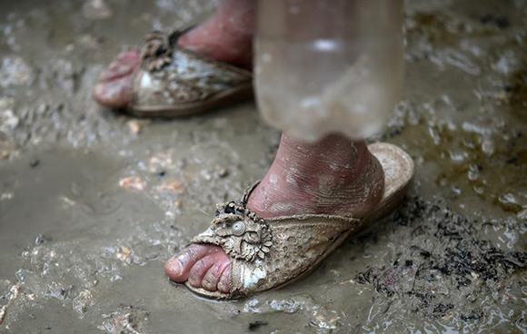  An internally displaced Syrian girl stands in the mud after heavy rain at a camp on the outskirts of Azaz, Syria January 26, 2018. Photo by Umit Bektas 