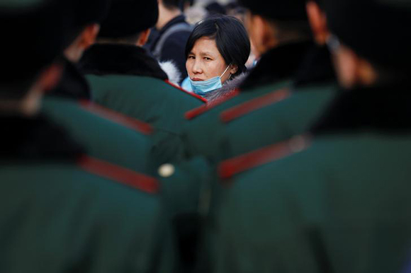  A passenger looks at security personnel deployed at the Beijing Railway Station as the annual Spring Festival travel rush begins ahead of the Chinese Lunar New Year, in central Beijing, China February 1, 2018. Photo by Damir Sagolj 