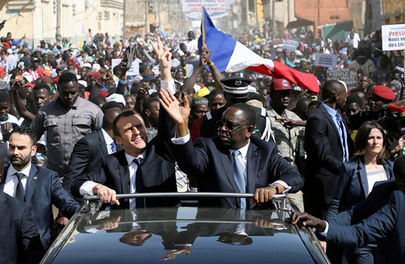  French President Emmanuel Macron and Senegalese President Macky Sall wave to the crowd from a car in Saint-Louis, Senegal, February 3, 2018. Photo by Ludovic Marin 