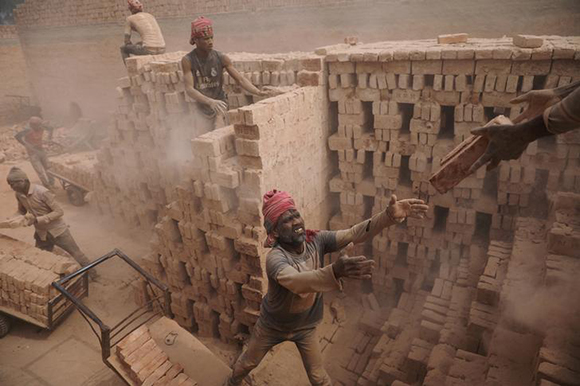  Brick factory workers stack bricks on a cart to take them to the warehouse in Dhaka, Bangladesh February 6, 2018. Photo by Mohammad Ponir Hossain 