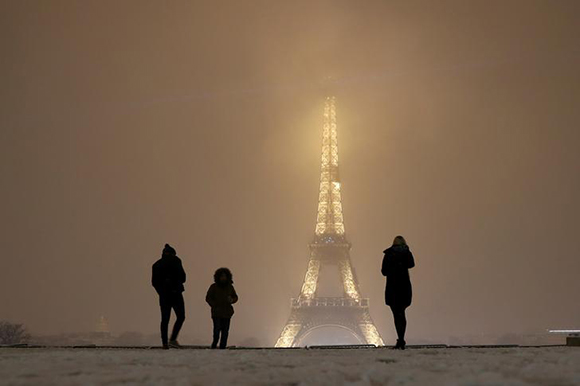  Tourists take pictures as they walk on a snow-covered path near the Eiffel Tower in Paris, as winter weather with snow and freezing temperatures arrive in France, February 6, 2018. Photo by Gonzalo Fuentes 