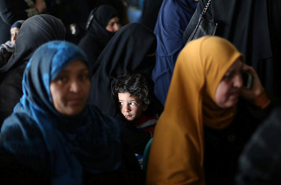  A boy looks on as he waits with his mother for a permit to cross into Egypt through the Rafah border crossing after it was opened by Egyptian authorities for humanitarian cases, in the southern Gaza Strip February 7, 2018. Photo by Ibraheem Abu Mustafa 