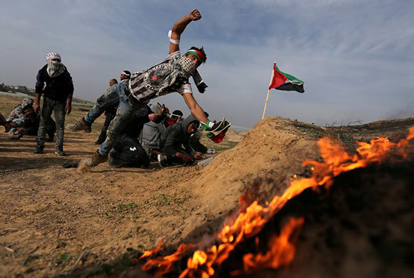  A Palestinian demonstrator reacts during clashes with Israeli troops, near the border with Israel in the southern Gaza Strip February 9, 2018. Photo by Ibraheem Abu Mustafa 