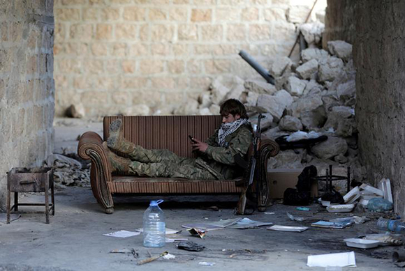  Turkey-backed Free Syrian Army fighter holds a mobile phone in the town of Tadef in Aleppo Governorate, Syria Photo by Khalil Ashawi 