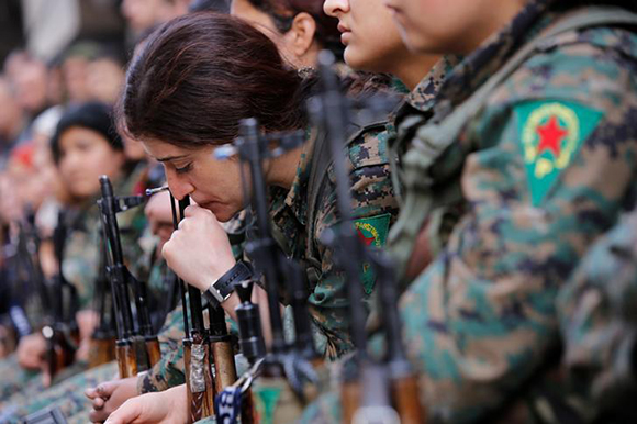  A Kurdish female fighter of the Women's Protection Unit (YPJ) gestures as she sits in the Sheikh Maksoud neighbourhood of Aleppo, Syria February 7, 2018. Photo by Omar Sanadiki 