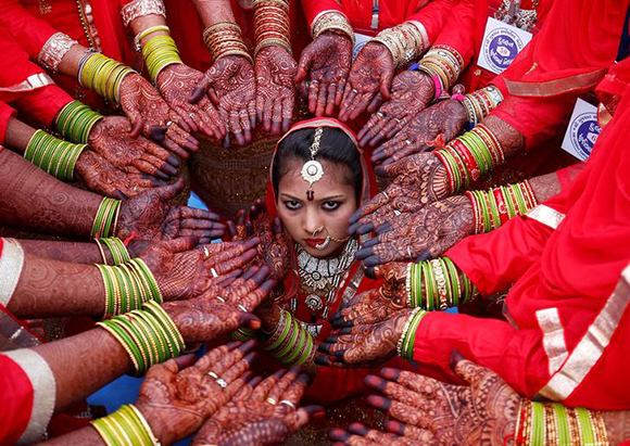  Brides display their hands decorated with henna around a bride as she poses for her own photographer during a mass marriage ceremony in which, according to its organizers, 70 Muslim couples took their wedding vows, in Ahmedabad, India Photo by Amit Dave 