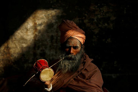  A Hindu holy man, or sadhu, plays a drum at the premises of Pashupatinath Temple on the eve of Shivaratri festival in Kathmandu, Nepal Photo by Navesh Chitrakar 