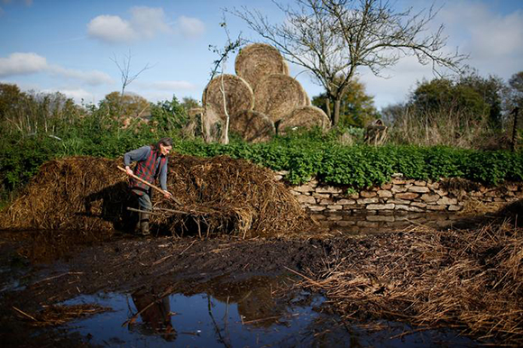  Laurence, companion of French farmer Jean-Bernard Huon, unloads manure on land near their farm in Riec-sur-Belon, France Photo by Stephane Mahe 