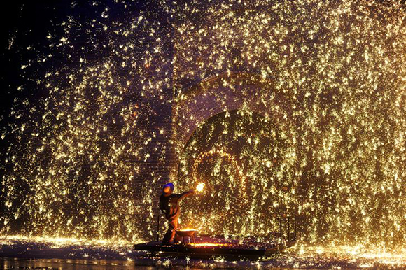  A performer sprays molten iron against a wall to create sparks during a traditional performance to celebrate Chinese Lunar New Year of the Dog in Zhangjiakou, Hebei province, China. Photo by Stringer 