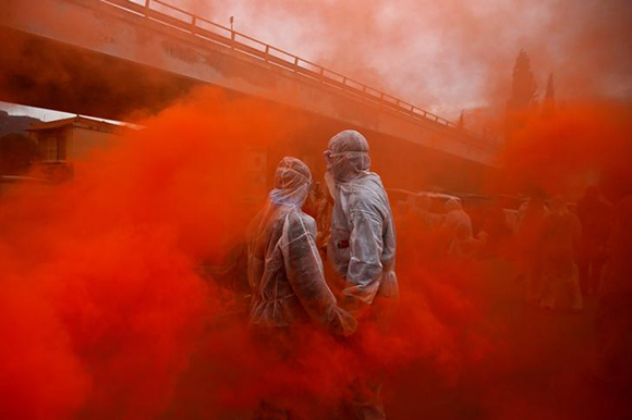  Two revellers are seen amid flare smoke as they celebrate "Ash Monday" by participating in a colourful "flour war", a traditional festivity marking the end of the carnival season and the start of the 40-day Lent period until the Orthodox Easter, in the port town of Galaxidi, Greece. Photo by Alkis Konstantinidis 