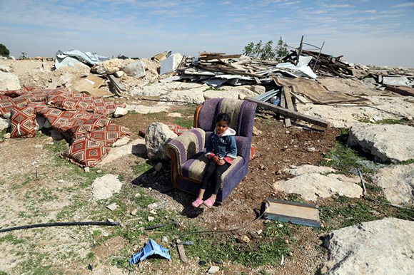  A Palestinian girl sits on a couch after Israel troops destroyed a Palestinian structure in the village of Al-Eizariya, in the occupied West Bank, east of Jerusalem February 20, 2018. Photo by Ammar Awad 