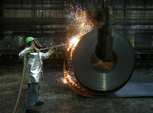  A worker cuts a piece from a steel coil at the Novolipetsk Steel PAO steel mill in Farrell, Pennsylvania, U.S., March 9, 2018. Photo by Aaron Josefczyk 