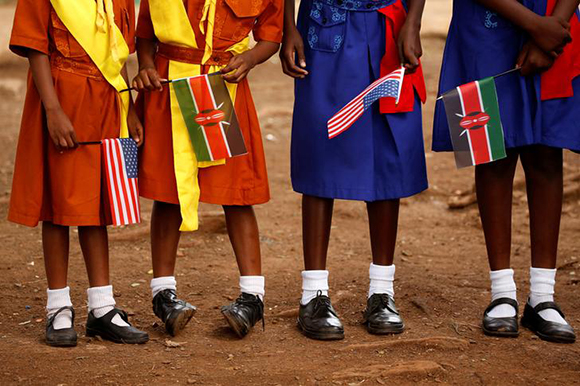  Young girls with U.S. and Kenya flags wait to greet U.S. Ambassador to Kenya Robert Godec as he visits a President's Emergency Plan for AIDS Relief (PEPFAR) project for girls' empowerment in Nairobi, Kenya, March 10, 2018. Photo by Jonathan Ernst 