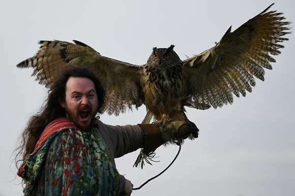  Druid Malachy, played by Ciaron Davies, reacts with a European eagle-owl named 'Cracker' during the re-enactment of the first landing of Saint Patrick in Ireland at Inch Abbey in Downpatrick, Northern Ireland Photo by Clodagh Kilcoyne 