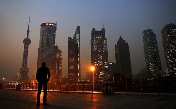  A man looks at the Pudong financial district of Shanghai Photo by Carlos Barria 