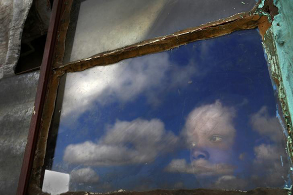  Anda, a 15 year-old local boy, watches from his hut's window the burial ground of late former South African President Nelson Mandela ahead of his funeral in Qunu Photo by Yannis Behrakis 