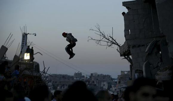  A Palestinian youth practices his Parkour skills over the ruins of houses, that witnesses said were destroyed during a 50-day war last summer in the Shejaia neighborhood east of Gaza City Photo by Mohammed Salem 