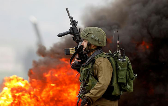  An Israeli soldier takes up position during clashes with Palestinian protesters near Nablus, in the occupied West Bank February 23, 2018. Photo by Mohamad Torokman 