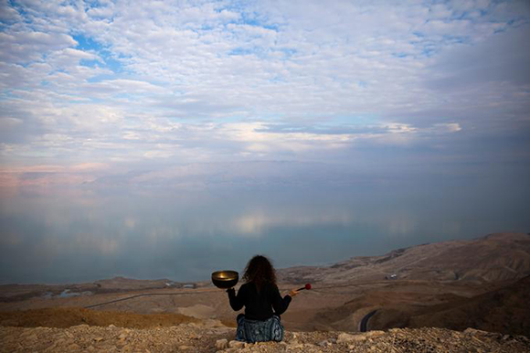  Jade holds a Tibetan singing bowl as she sits on a cliff overlooking the Dead Sea, near Metzoke Dragot in the Israeli occupied West Bank Photo by Ronen Zvulun 