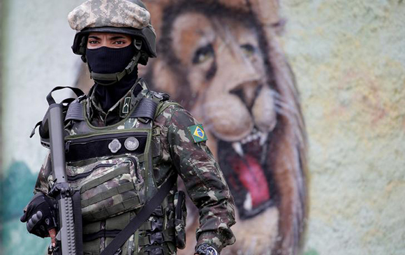  An armed forces member patrols during an operation against drug dealers in Vila Alianca slum, in Rio de Janeiro, Brazil Photo by Ricardo Moraes 